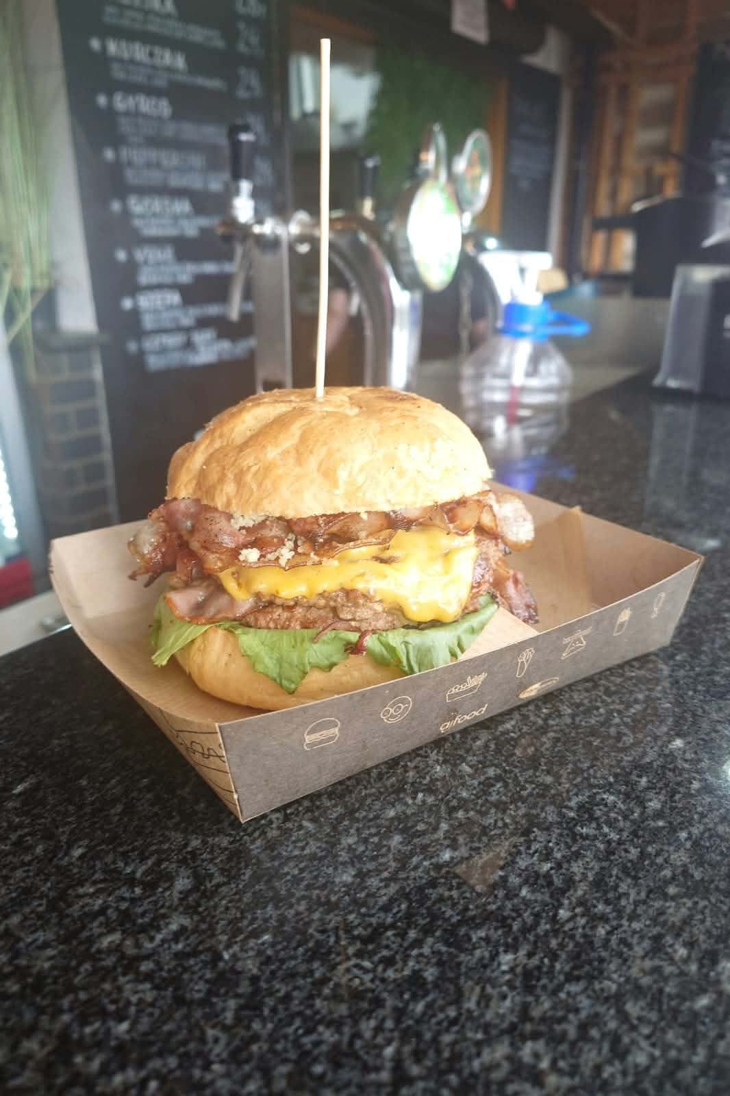 Burger z bekonem, roztopionym cheddarem i sałatą