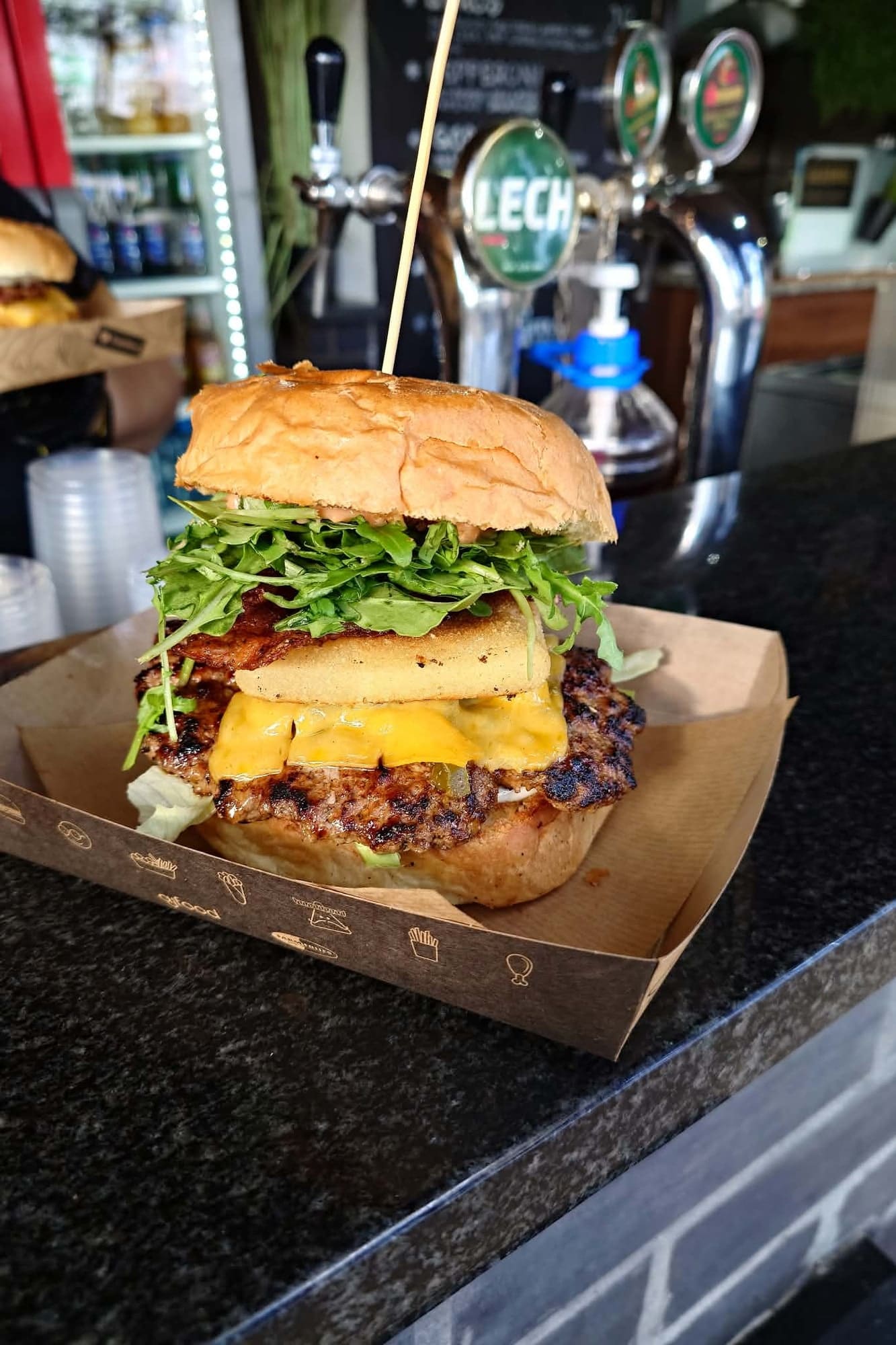 Wysoki burger z grillowanym serem, bekonem i rukolą